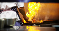 Chef cooking over flame at