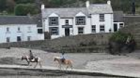 A pub and two horse riders in